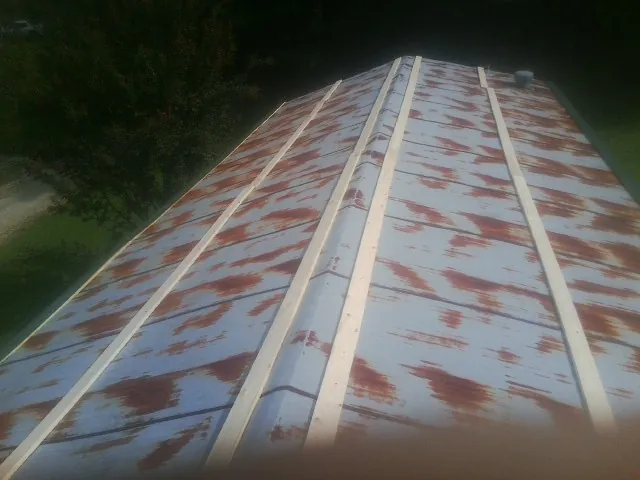 Rusted metal roof panels with new wood purlins before replacement — Storm Damage Roof Repair in Narragansett by Roofing Brothers