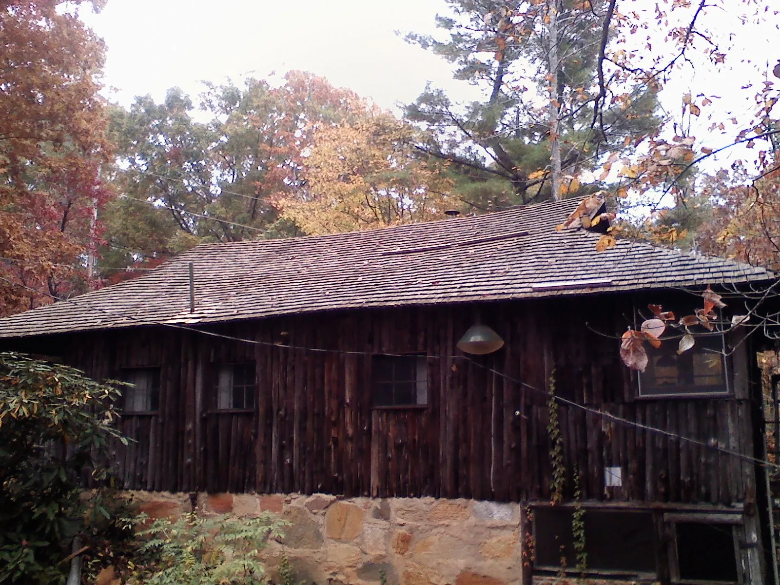 Weathered wood shake roof on a rustic board sided cabin in Narragansett