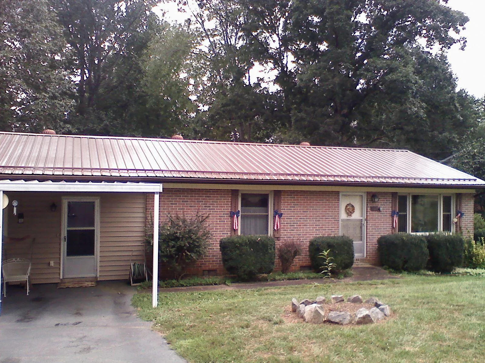 Bronze metal roof and carport on a brick ranch home — Roof Repair work by our crew in Narragansett